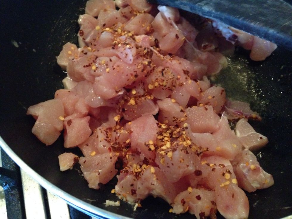 Add boneless chicken pieces to preheated oil in frypan and add ground red pepper according to taste (about 1 tsp)