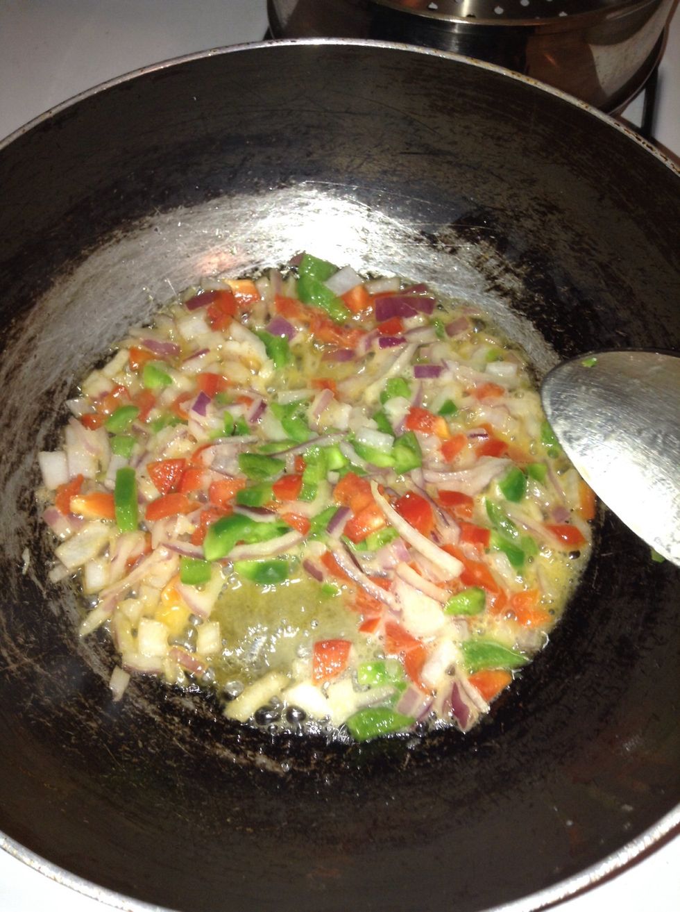 Add butter to a medium saucepan at medium heat until the butter melts. As soon as the butter melts , add the onions, bell peppers and hot pepper/ flakes and saut\u00e9 until onions are translucent