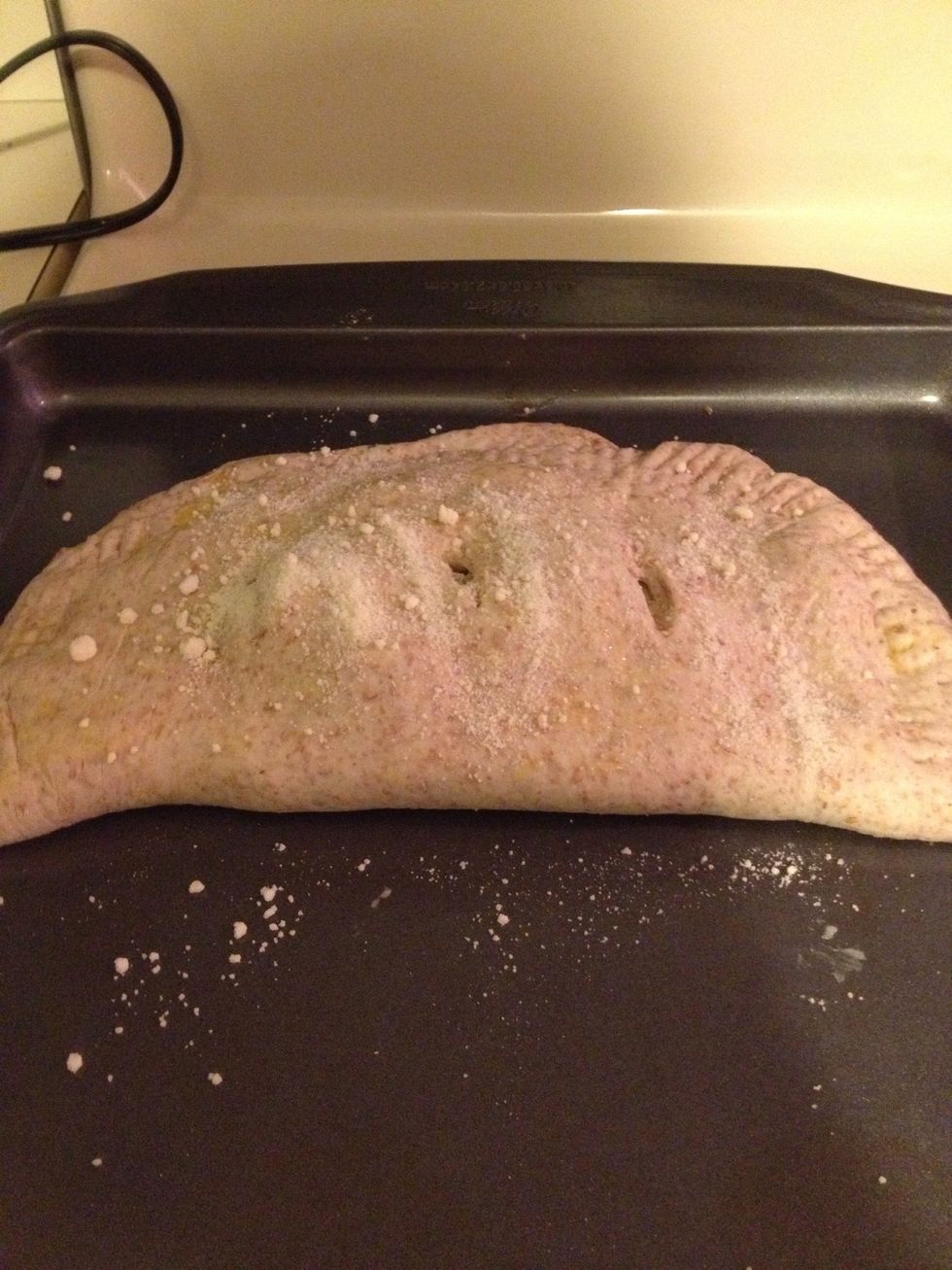 Add butter to top surface of dough and make three cuts into top part of dough. This allows air to enter calzone and Cooke the ingredients. Optional: you can sprinkle cheese on top of butter! Mhm