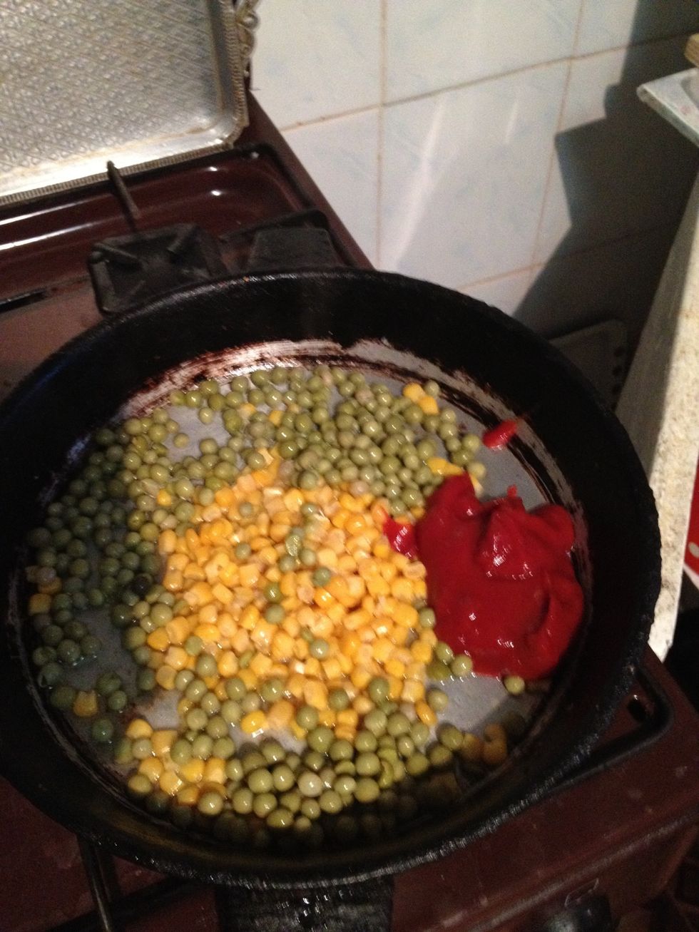 Add canned corn, canned peas, and tomato sauce