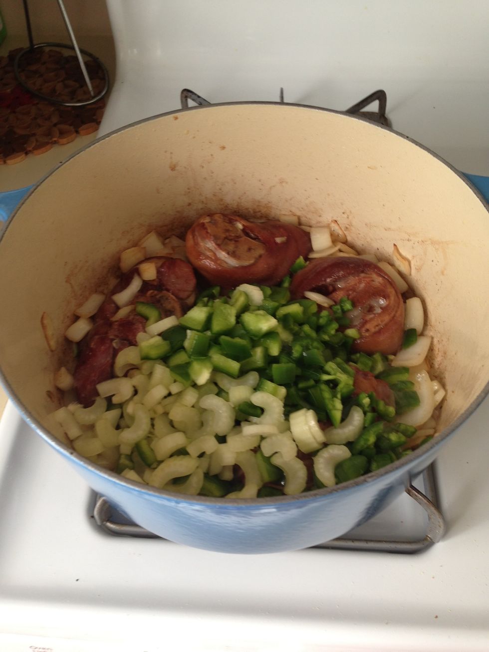 Add celery, bell pepper, garlic, and jalape\u00f1os. Again, cook around 4 minutes, then add the oregano and and bay leaf and give it all a good stir.
