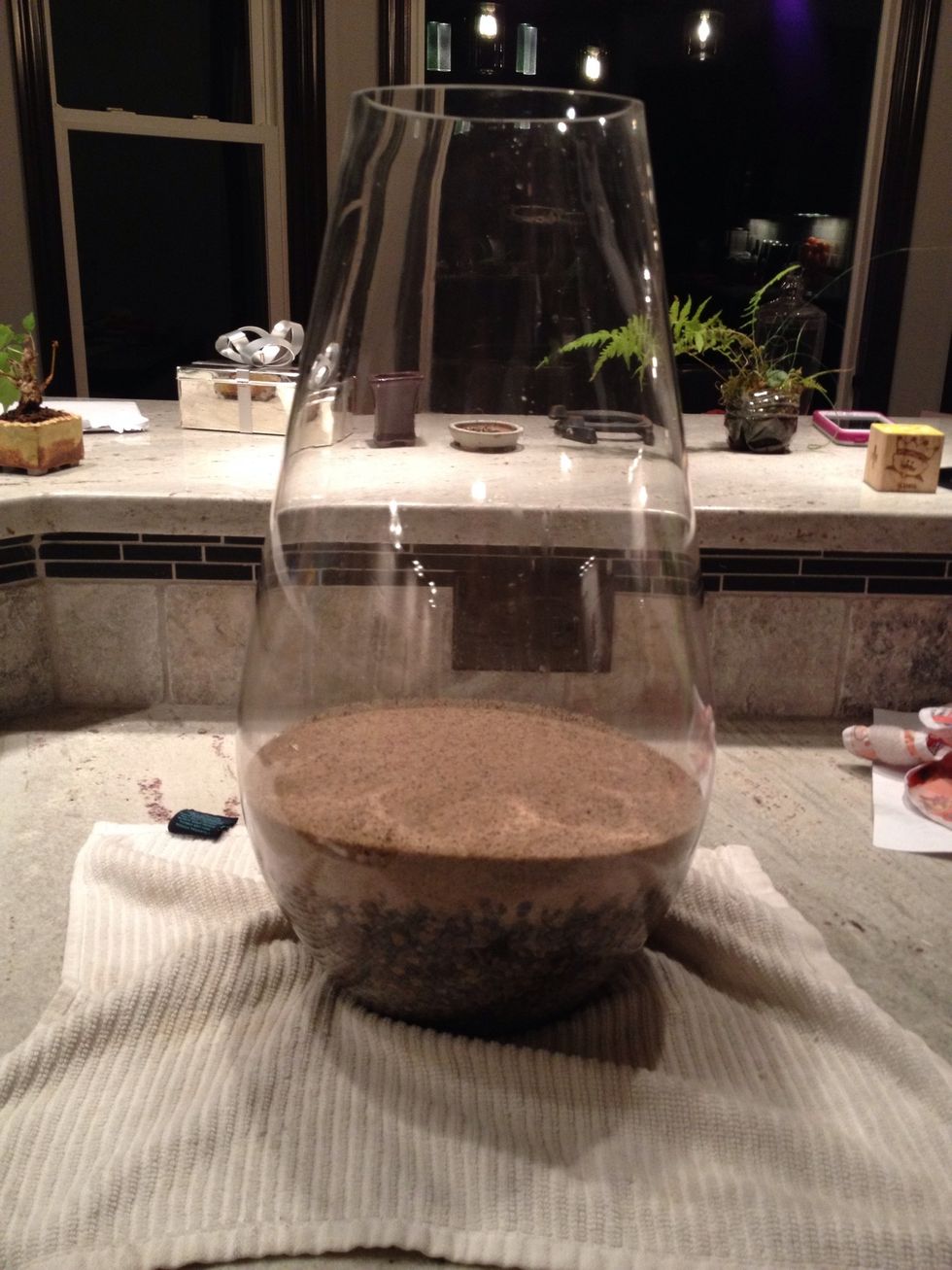 Add *charcoal and then sand.   *charcoal is optional and helps clean impurities.