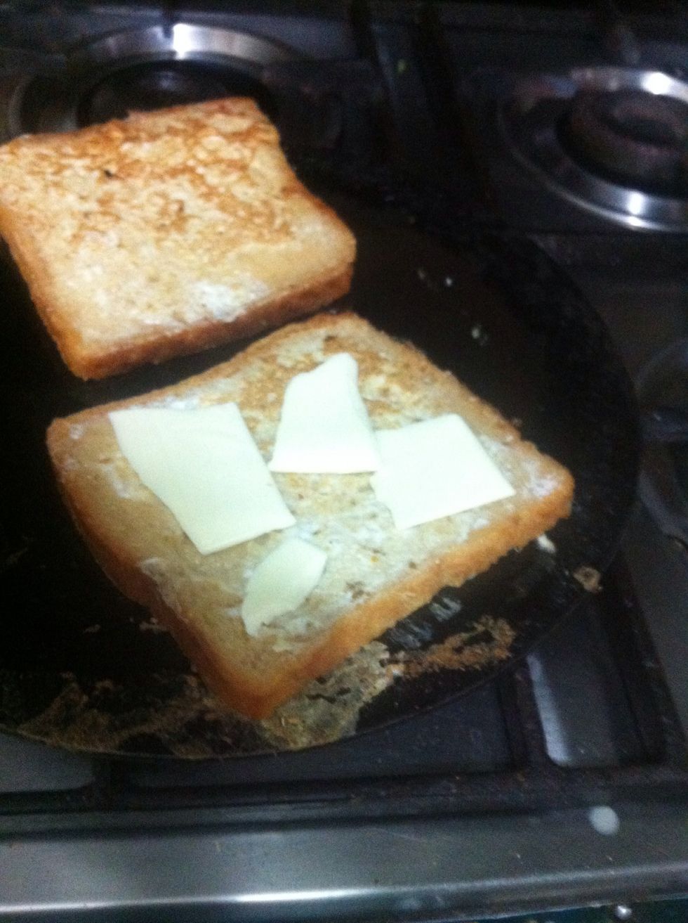 Add cheese to the cooked side of one piece. You can add whole slice. I am a lil conscious :p And cover with the other slice of bread