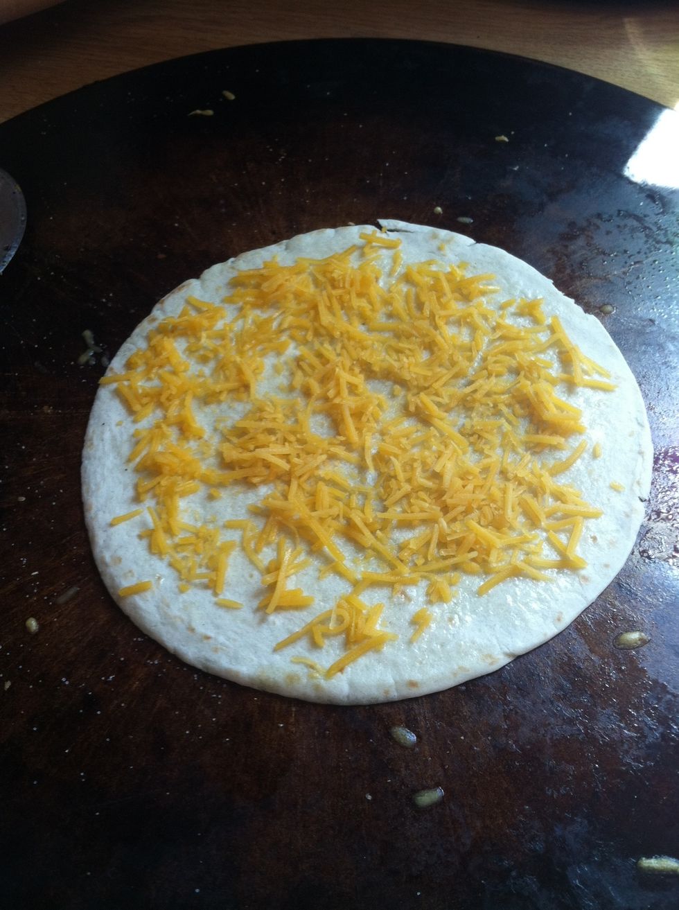 Add cheese to the tortilla. You can put a lot or a little.