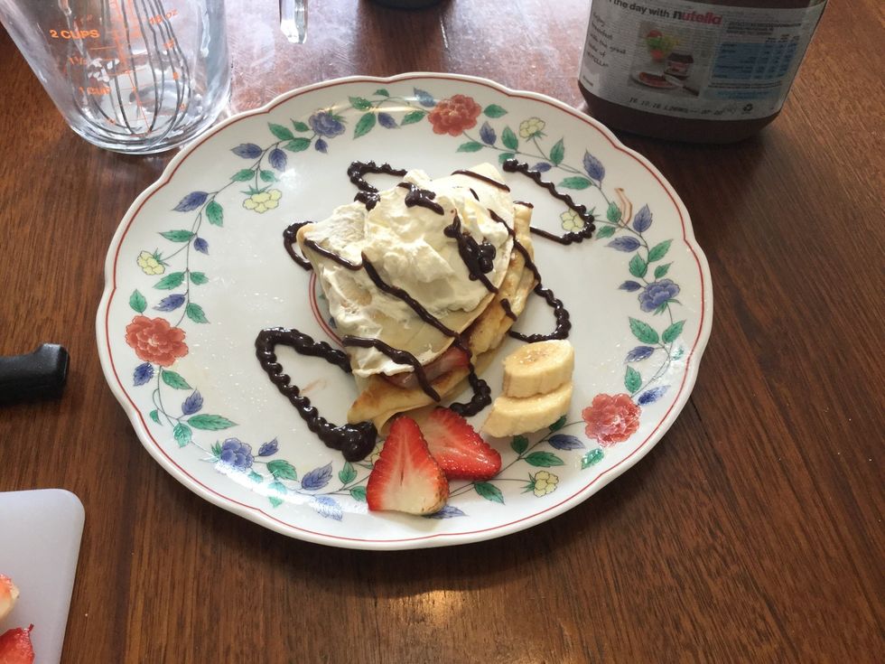Add chocolate syrup on top of the whipped cream. And add some left over fruit around your crepe for decoration.