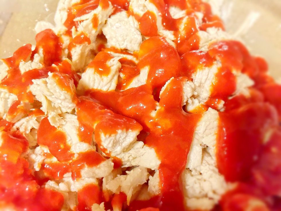 Add chopped chicken to skillet with 1 tbsp olive oil. Cook until done. Put cooked chicken in bowl and shred with fork. Stir in 4 tbsp sriracha (more or less for your personal preference).