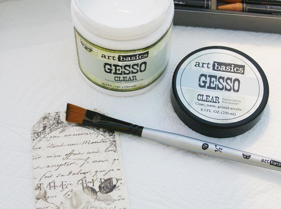Add clear gesso over Paintable tag. Dry. This protects the image beneath, & provides a smooth base for easy blending. If you do not like the color results you can simply wipe them off and start again.