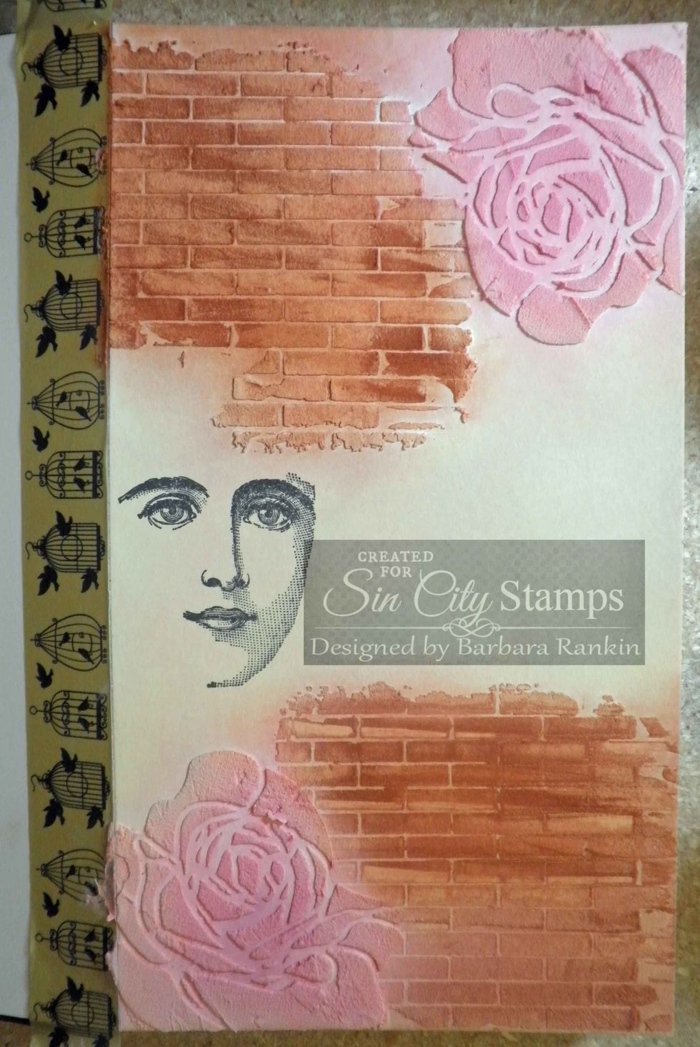 Add color to journal page with Pan Pastels Burnt Sienna (bricks), Permanent Red Tint and Magenta (roses), Hansa Yellow Tint & Ultramarine Blue Tint (background). Stamp face with black ink, as shown.
