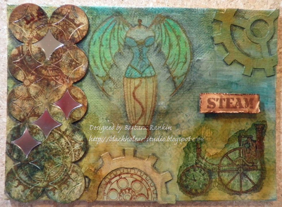 Add Derwent Inktense Blocks colors to winged dress form to further intensify the image. Add metal embellishments.