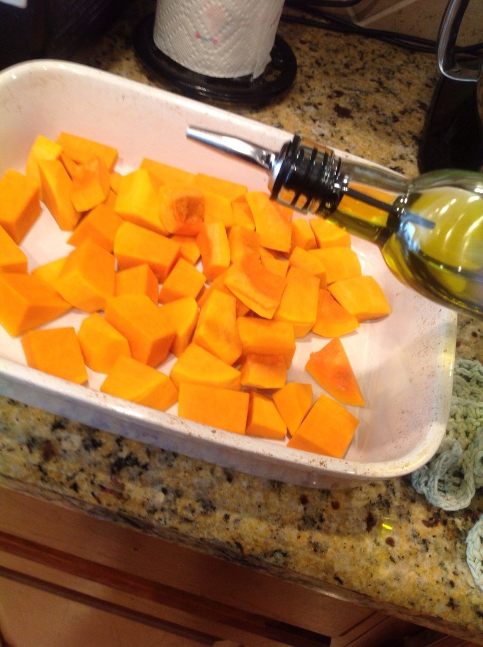 Add diced squash to a roasting pan. Drizzle with a little olive oil.