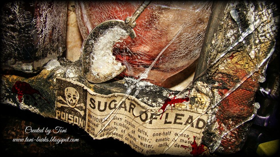 Add distressed glitter in rock candy to spoon with adhesivce. . Using hot glue gun allow the glue to drip and string along the canvas for a spider web effect.