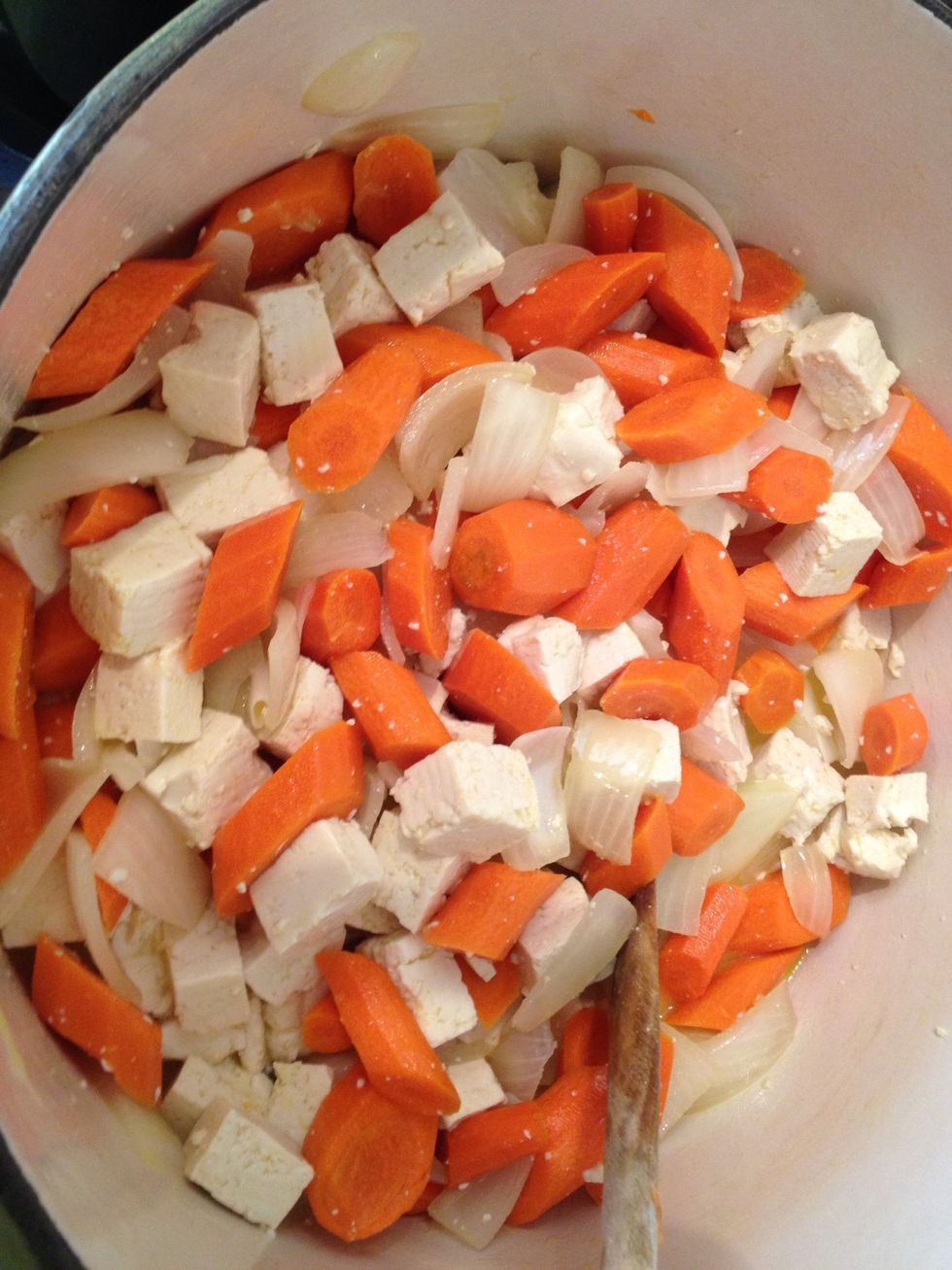Add drained tofu blocks to the vegetable saut\u00e9. In a sauce pan, mix 50ml or more of yellow curry paste with 2 Tblsp of olive oil. Pour in the can of coconut milk. Stir.