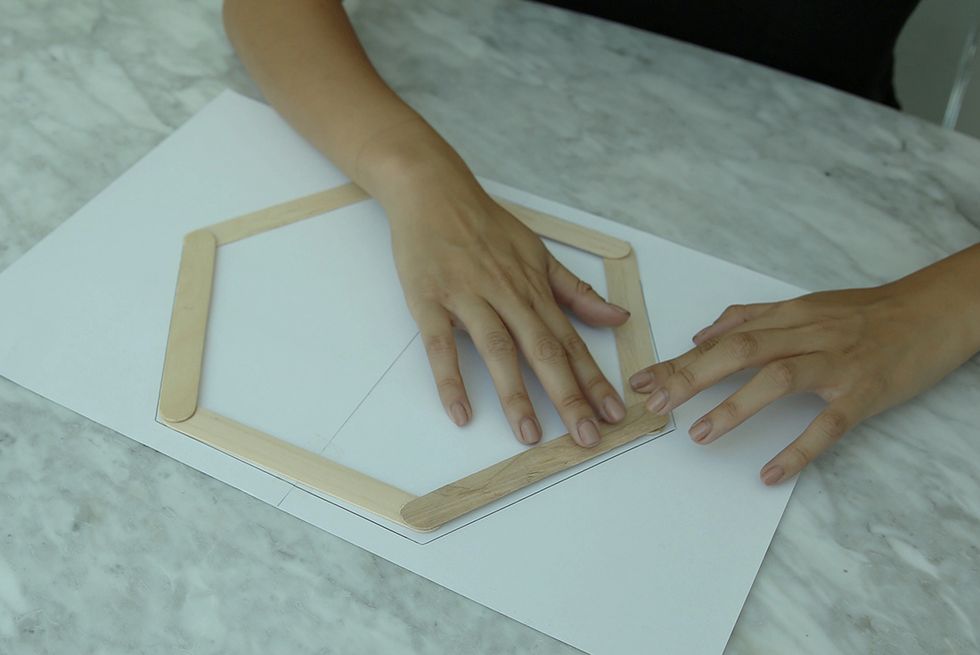 Add drops of glue to each side of each craft stick. Then proceed to add three additional sticks, layering them so that each side alternates sitting over or under another stick.