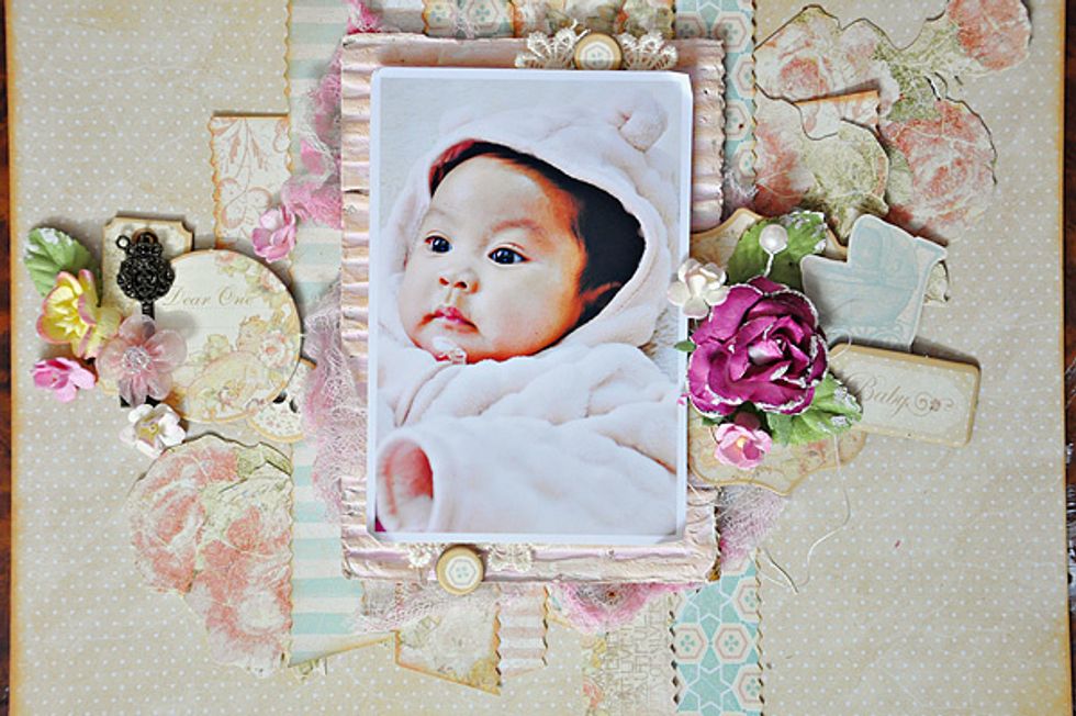 Add embellishments like flowers and chipboard pieces. I inked the edges of the chipboard pieces first like the strips of papers.