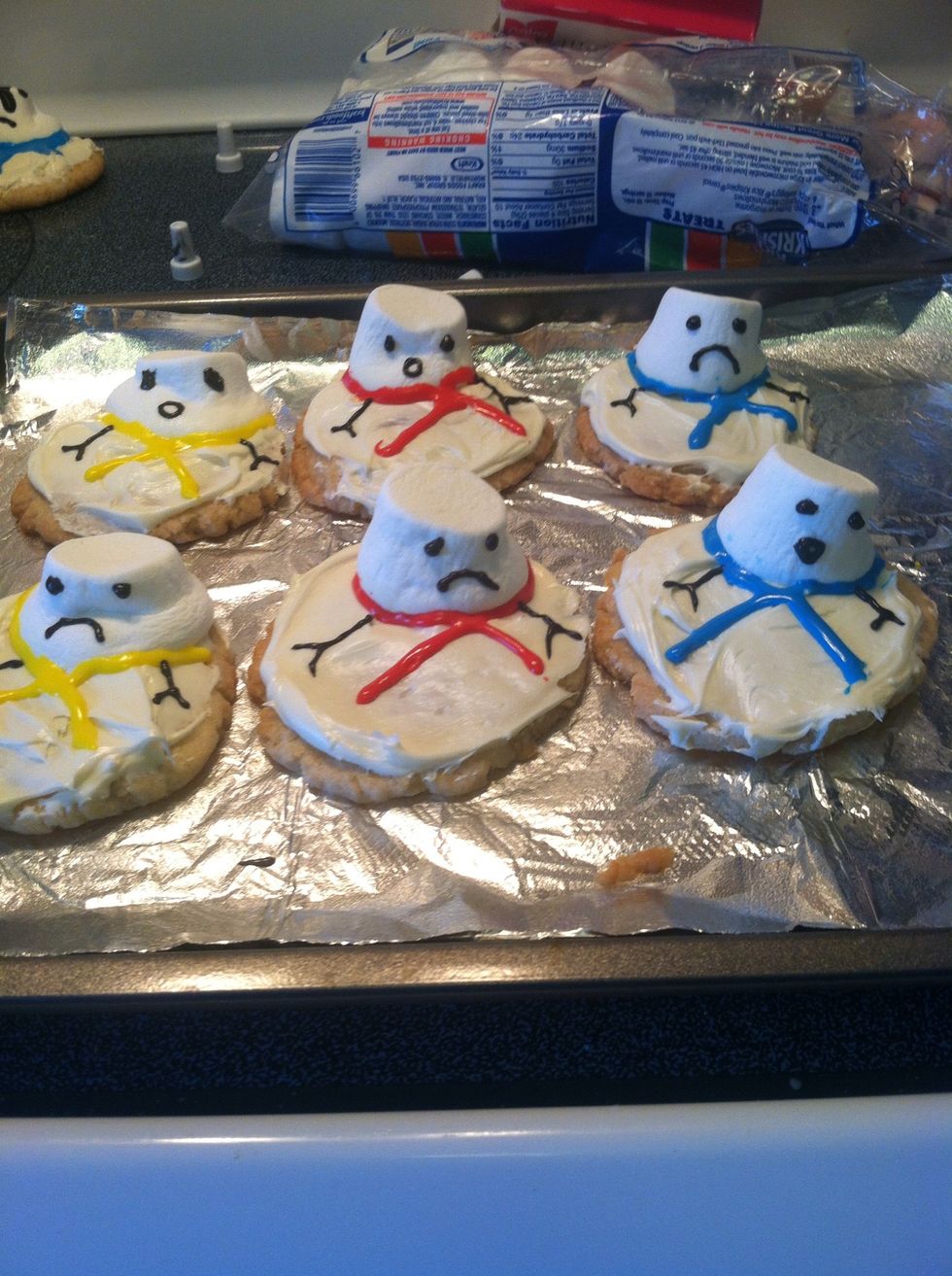 Add eyes, mouth, and arms. I made the brown color by mixing green, red, and blue food coloring together with the icing. Also, I made a piping bag by cutting the corner of a plastic sandwich baggie.