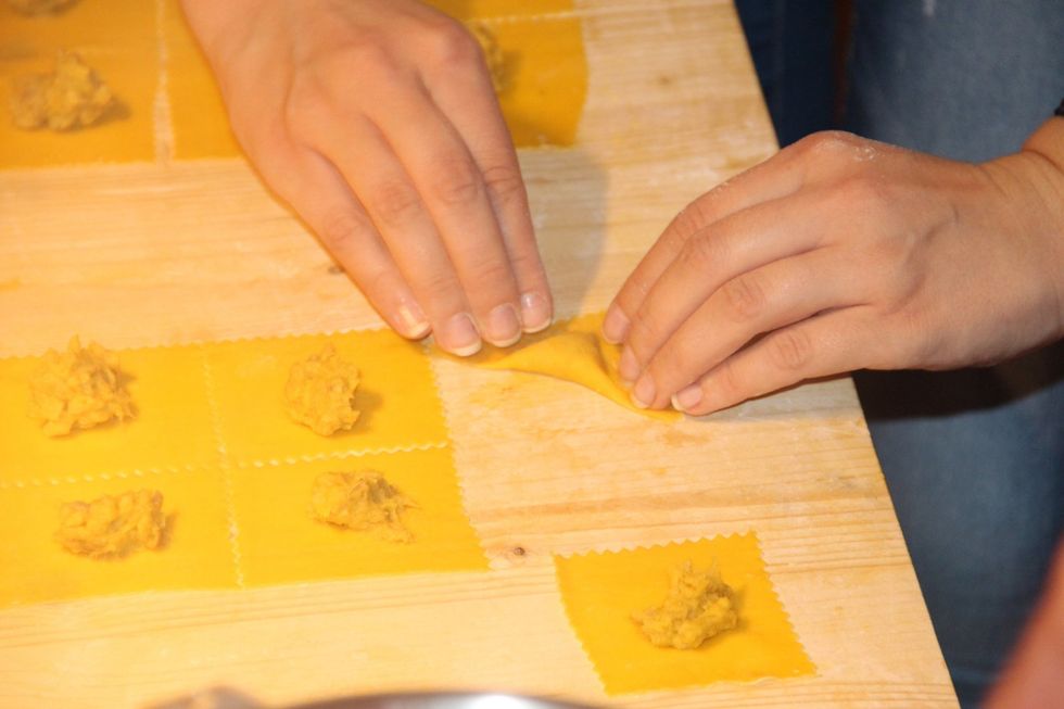 Add filling to square shapped pasta and fold in half from the edges like this