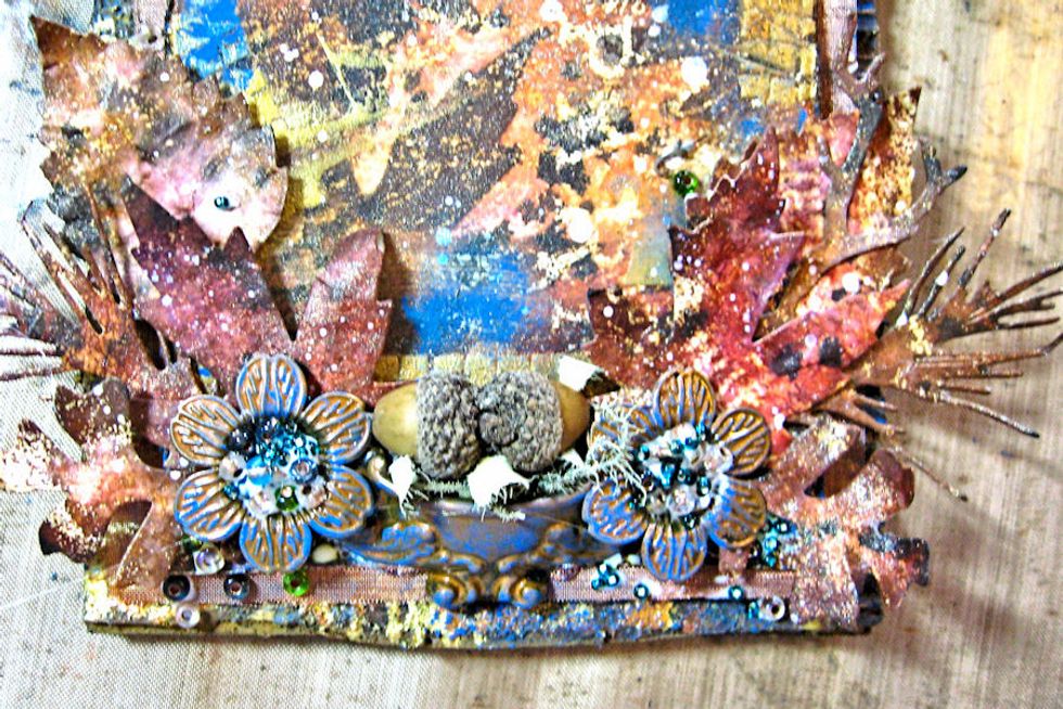 Add flowers and ornate door pull.  I filled the door pull with Spanish Moss and acorns I found while walking in the woods. you could also use flowers.  Fill the flower centers with glue.  Add beads.