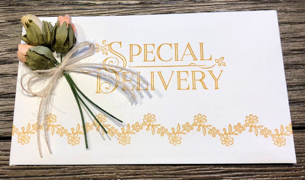 Add flowers and twine to the front of the envelope using hot glue. Your envelope is finished.