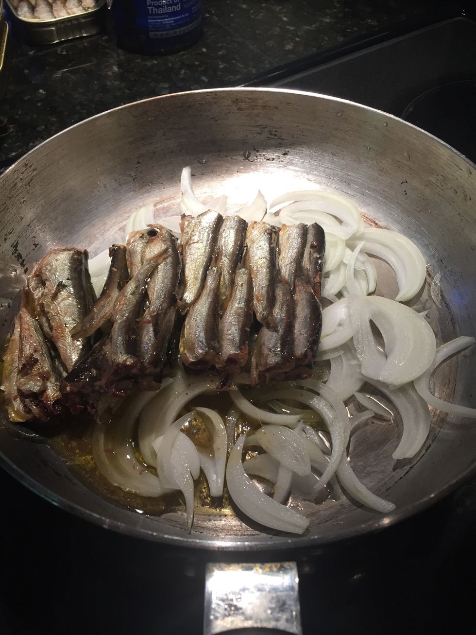 Add four cans of sardines to the pan