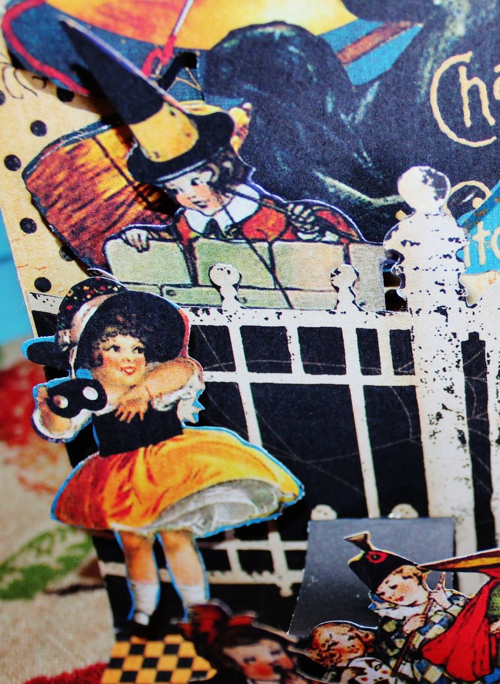 Add fussy cut images to pop up squares that have been formed. Placing a few of the cut images behind the fence.