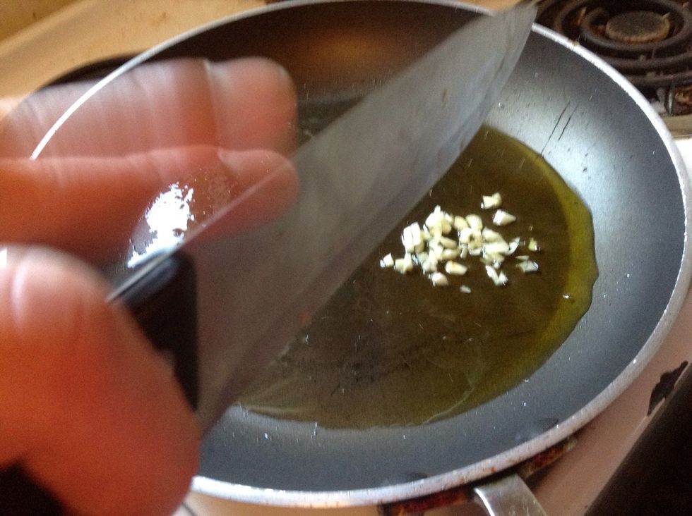 Add garlic to preheated olive oil and saut\u00e9e lightly
