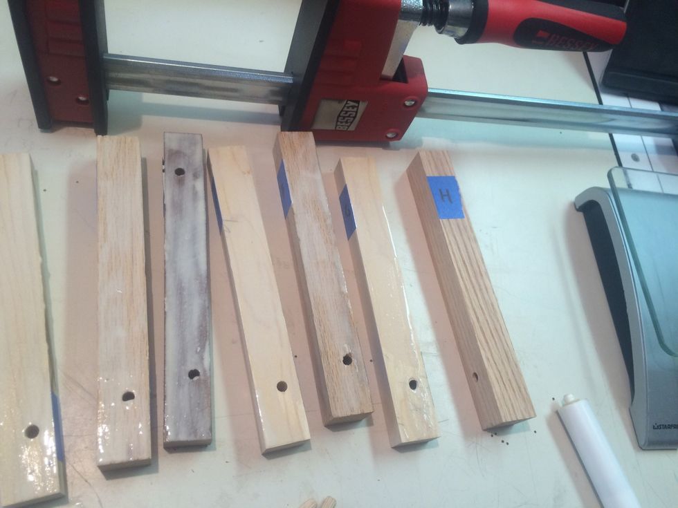 Add glue to all up facing surfaces except the last piece of wood on the right (piece H)