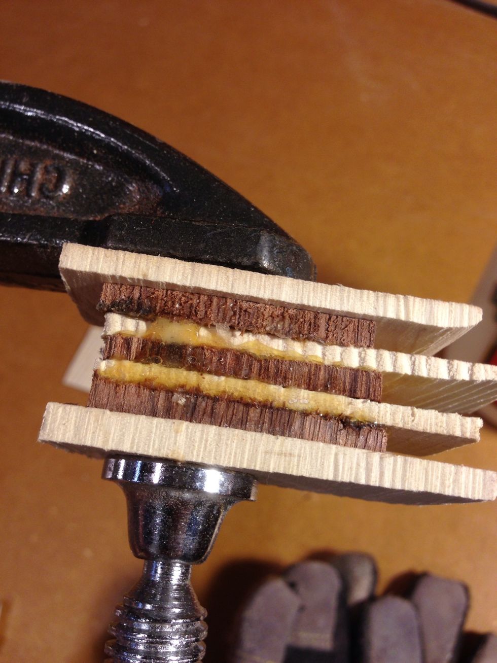 Add glue to each piece of wood and stack together and place in c clamp. The two outside pieces of wood or for compressing and have no glue. This is so you don't damage the wood.