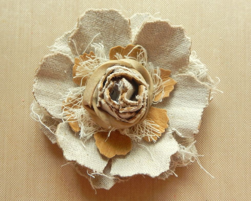 Add glue to the base inside the next inner layer, scrunch together around the central bud and secure with an elastic band until completely dry.