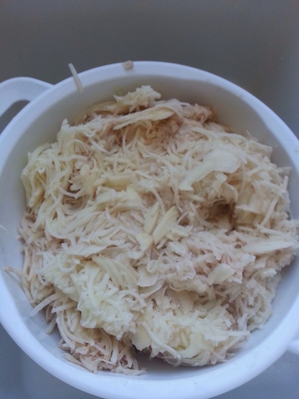 Add grated potatoes to a colander.