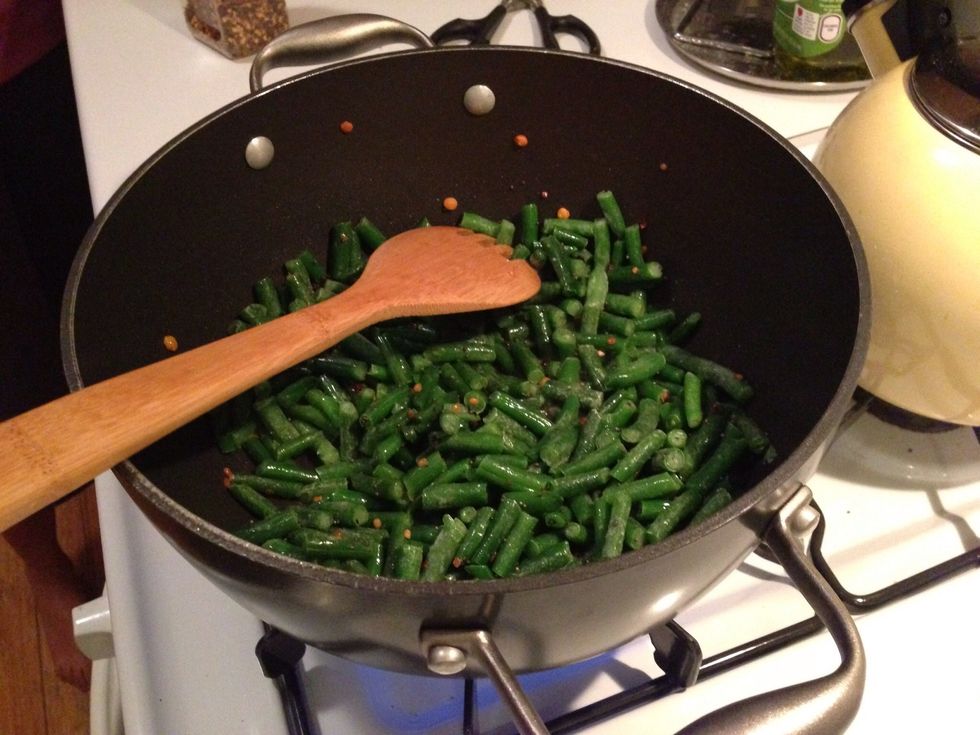 Add green beans, salt, water then stir.  Cover pot, simmer for 5 minutes
