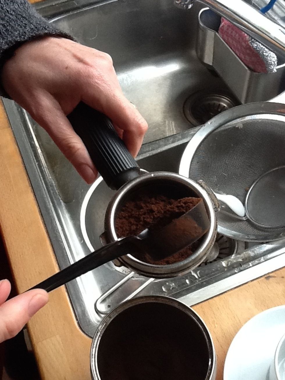 Add ground coffee to piston