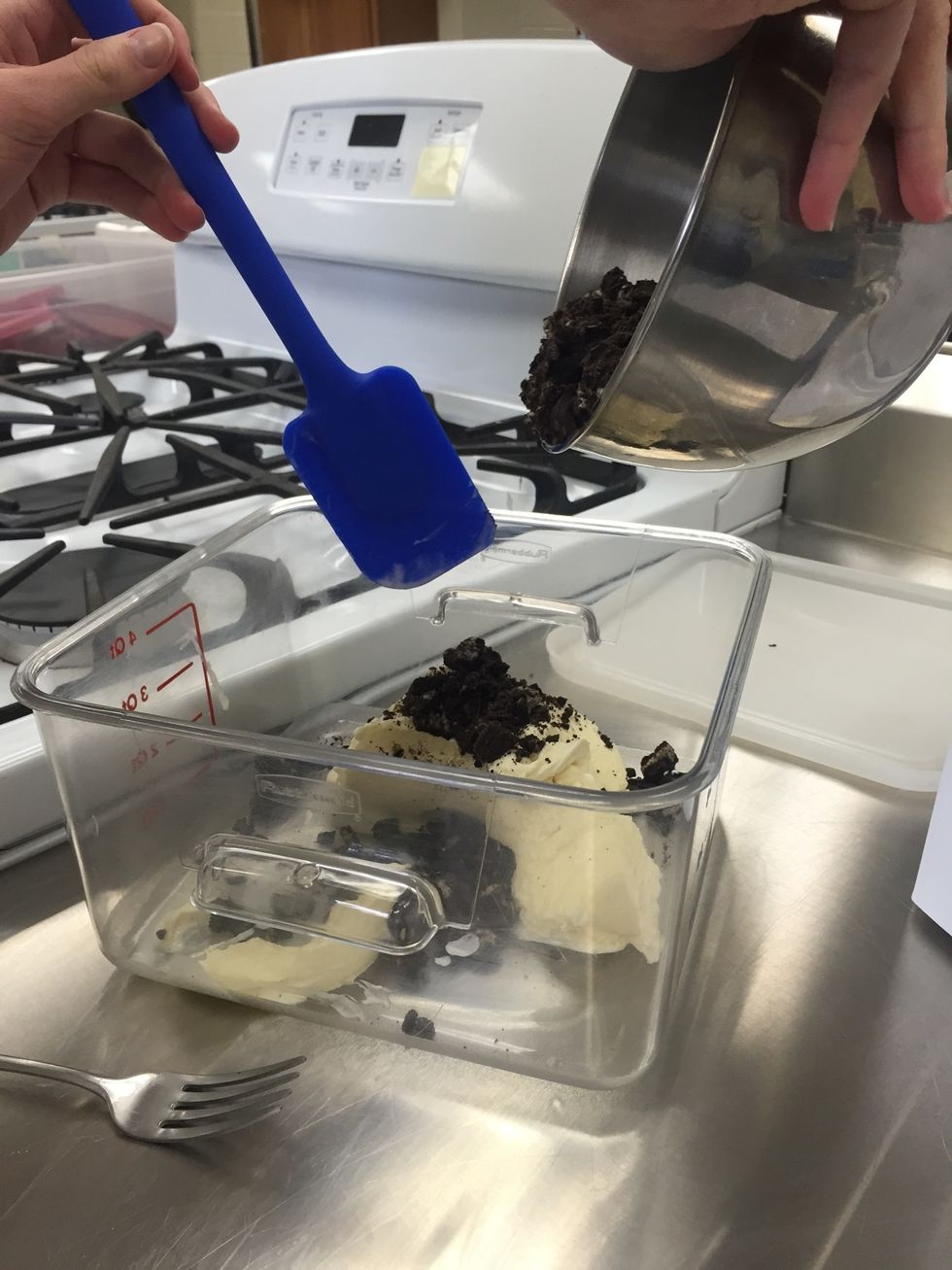 Add half of the chopped oreo pieces and fold in gently with a rubber spatula.