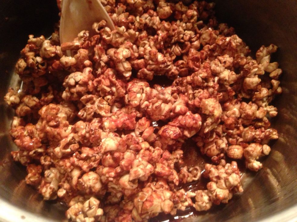 Add half of the popcorn to the pot. Stir gently until all the popcorn is fully coated.
