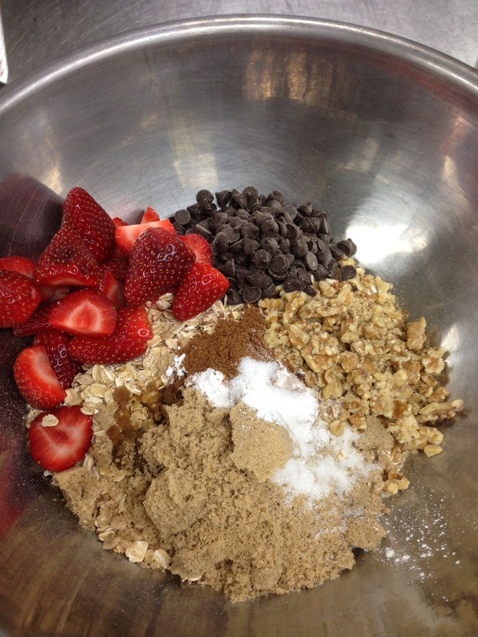 Add half of the strawberry slices. Then chocolate, orange zest and spices to the bowl.