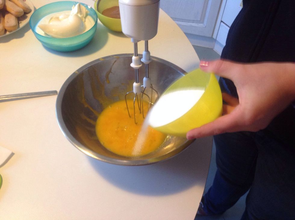 Add half of the sugar to the yolk.
