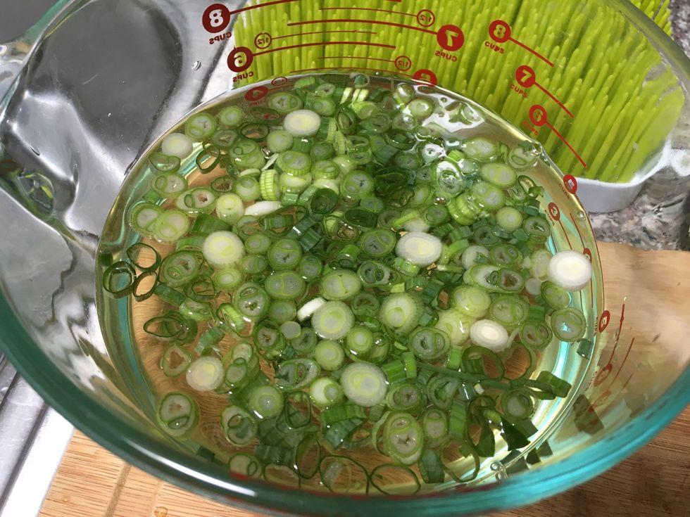Add half the chopped green onions to the beer water mixture.