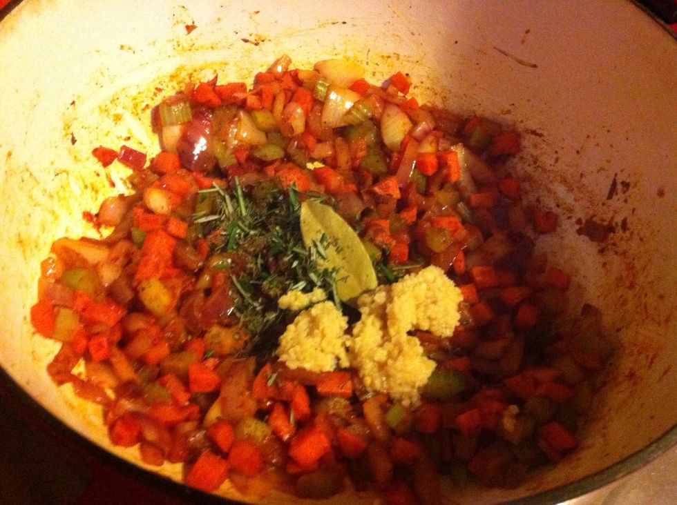 Add herbs, bay leaf tomato paste and garlic to the pot. Cook for 2 minutes.