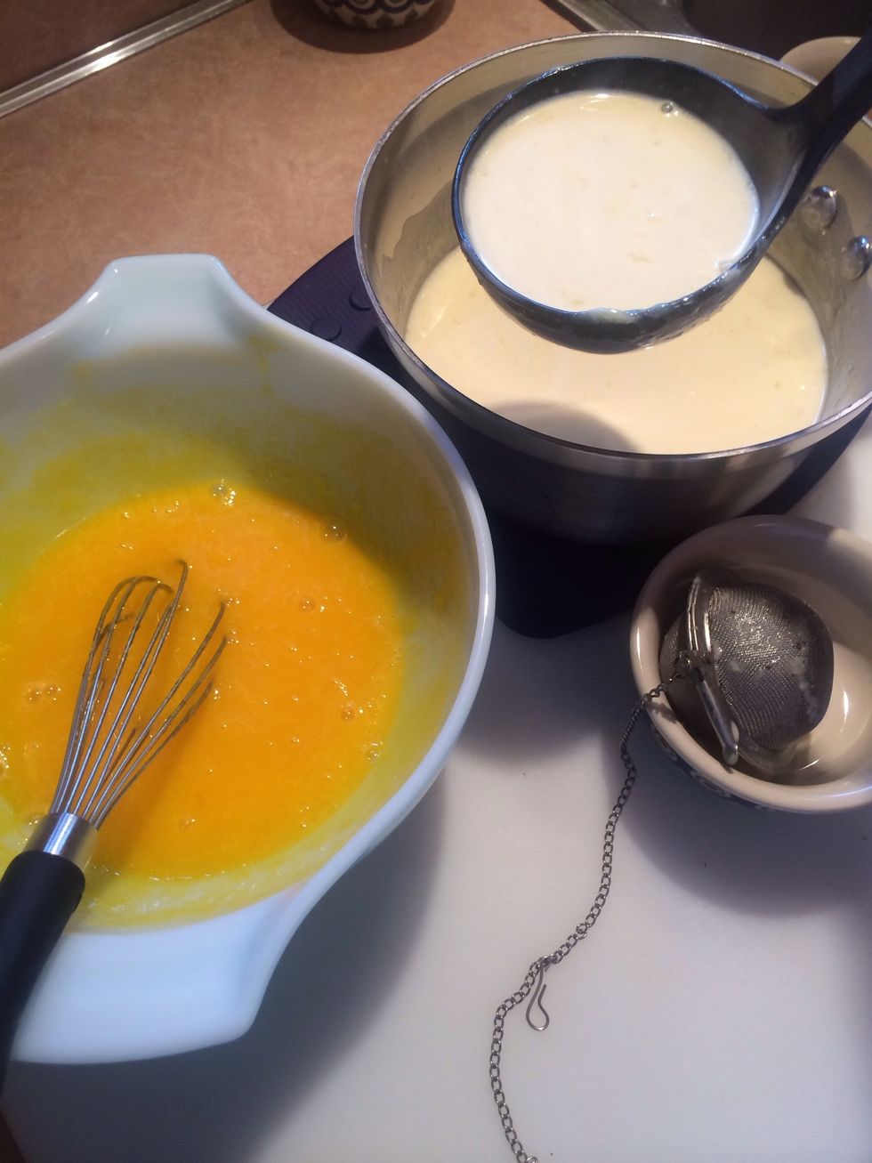 Add hot cream with a ladle to the cool eggs.