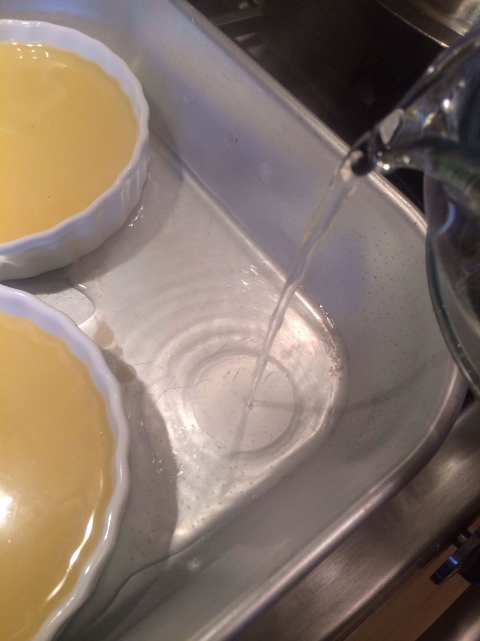 Add hot water to the roasting pan. We've just created a water bath. Be careful not to get water into the custard cups.
