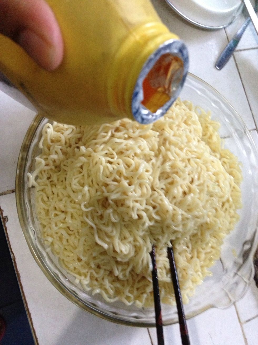 Add in 2 to 2..5 tbsp of canola oil and 1 tbsp of fish sauce. Mix it up. This will prevent the noodles from from sticking to each other and as a bonus, it will make them shiny