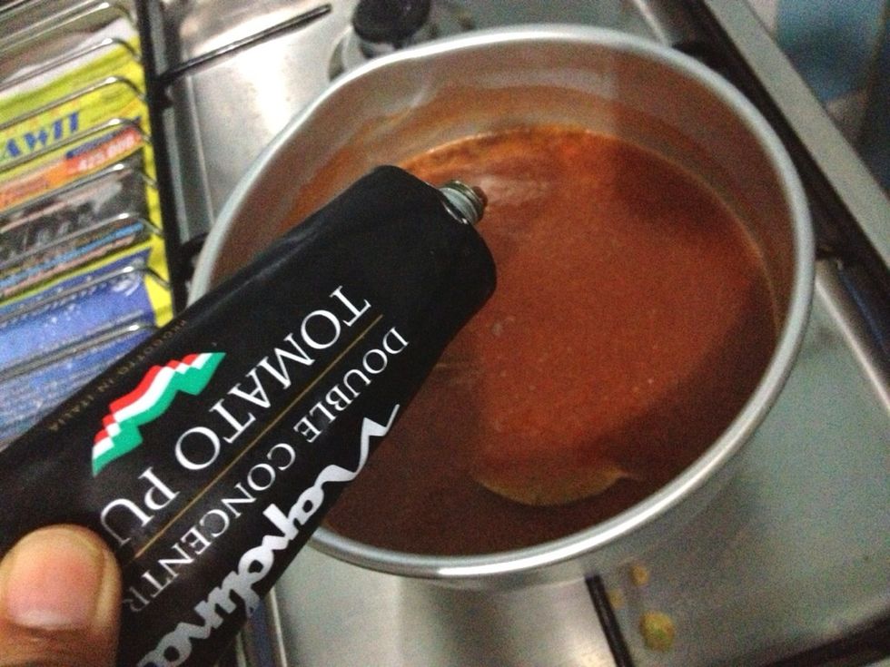 Add in 2 tsp of tomato puree. Stirring slowly