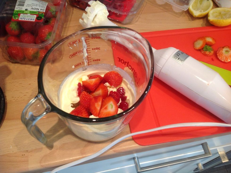 Add in a handful of sliced strawberries and raspberry and a table spoon of caster sugar and whisk again briefly to just incorporate the fruit