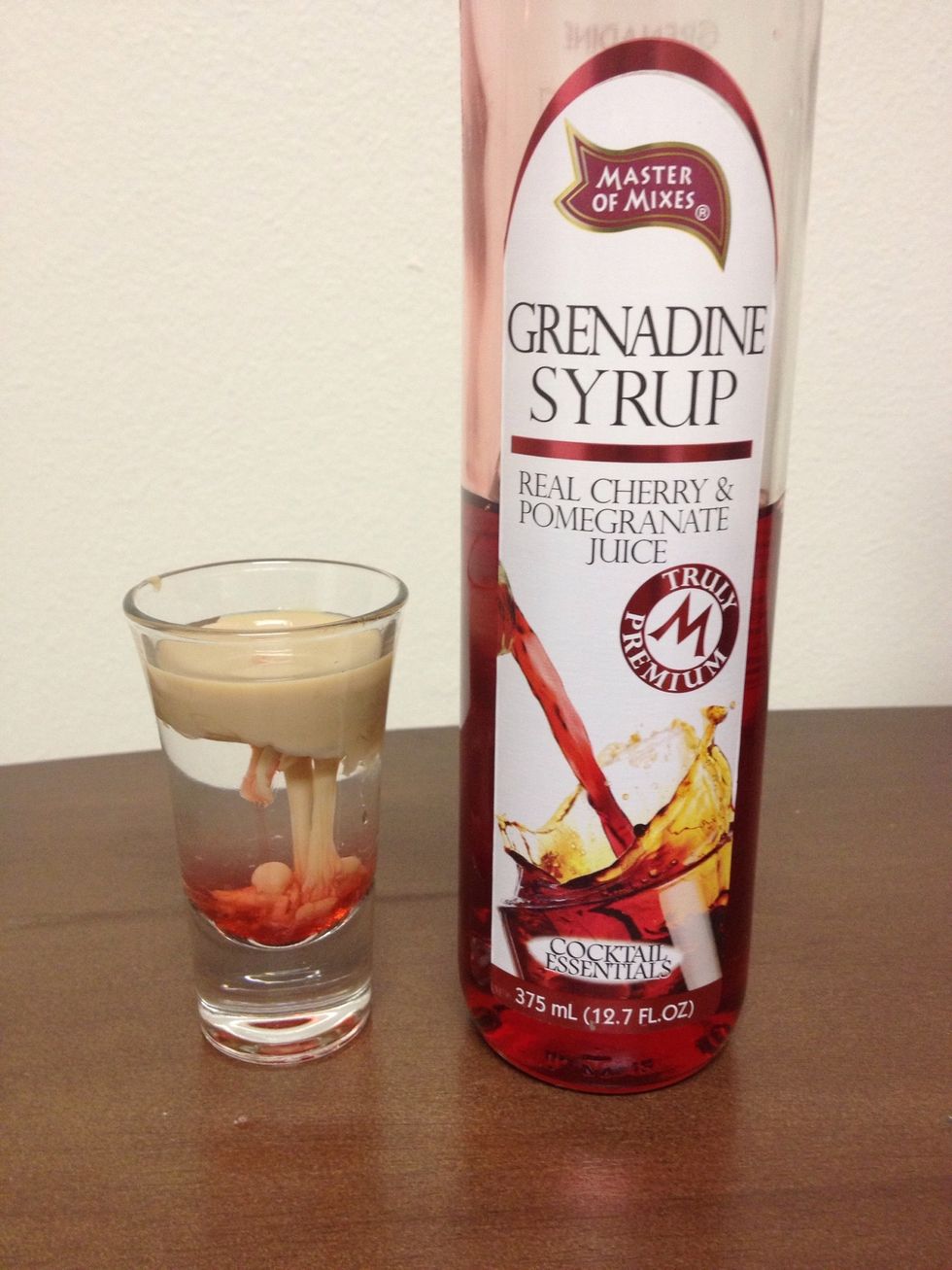 Add in a small amount of Grenadine. It should sink to the bottom and will drag some Cream with it.