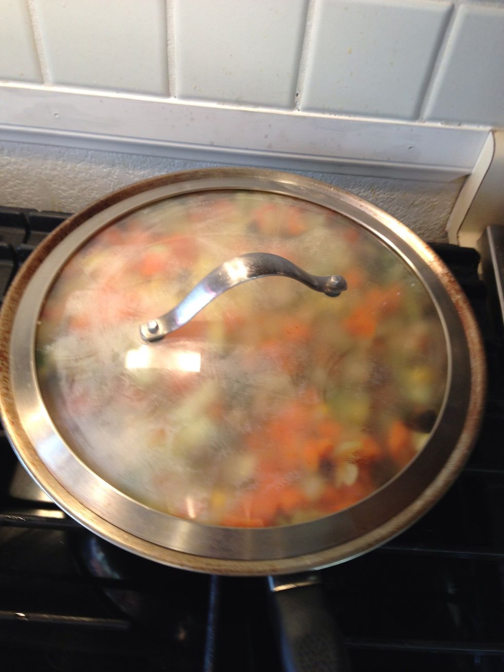 Add in a splash of water and cover the mixture leave on medium/high. Allow the veggies to cook for 5 minutes. Then stir and allow to cook for 5 more minutes or until the veggies are softened.