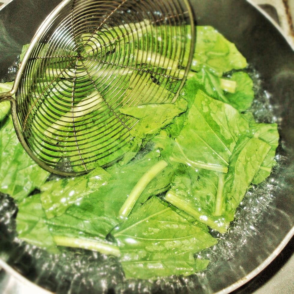 Add in the chopped mustard greens to the boiling water, toss a few times until it changes deep green (should take about 20-30 seconds). Do not overcook the greens.