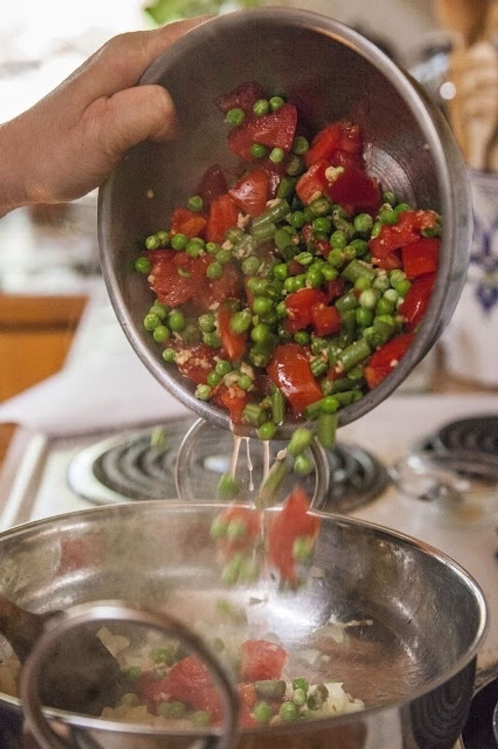 Add in the chopped onion and let it cook down for about 4 minutes or so. When it starts to turn a golden brown, add in the green beans, tomatoes, ginger and peas.