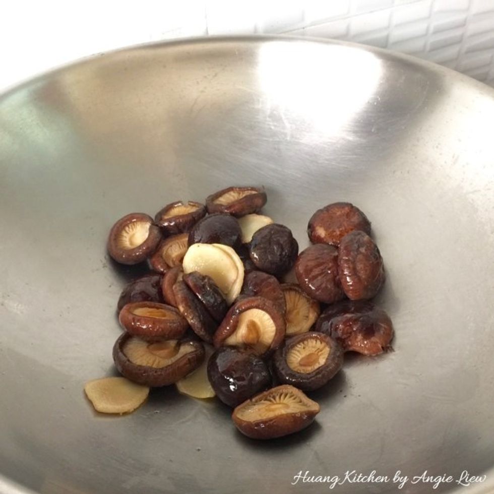 Add in the drained and rehydrated shiitake mushrooms. Stir fry the mushrooms until fragrant.