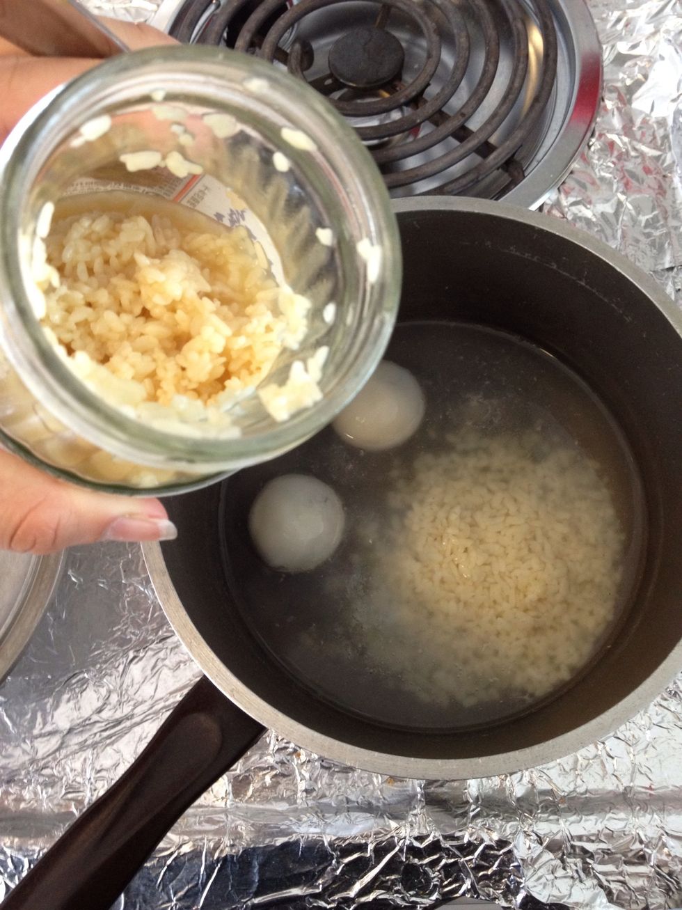 Add in the glutinous rice now, 1:1 to the water. Remember to scoop out some rice wine in the bottom, that's the best part. You can also add sugar now if you like it sweet, I like it the original way.