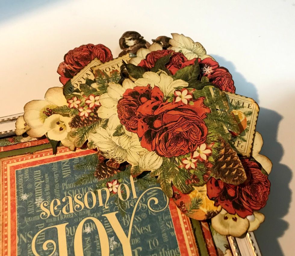 Add in the rest of the flowers where ever you have some open space. Make sure to add one more stamp on the right hand side of the arrangement. Roll one of the corners down on the stamp.