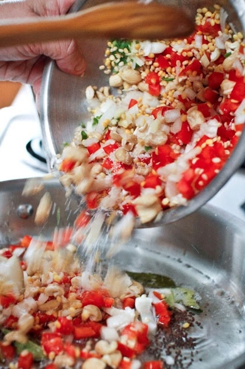 Add in the split peas, urad dal, cashews, bell pepper, green chili, ginger, salt and onion. Saute everything for 10 minutes or until the dal has turned color and the bell pepper has gotten tender.